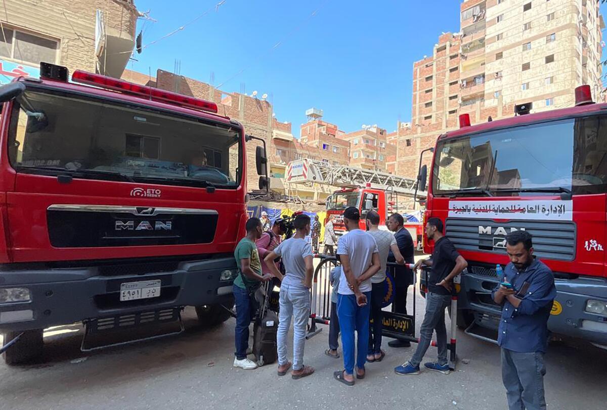 A small group stands next to emergency vehicles in Cairo.