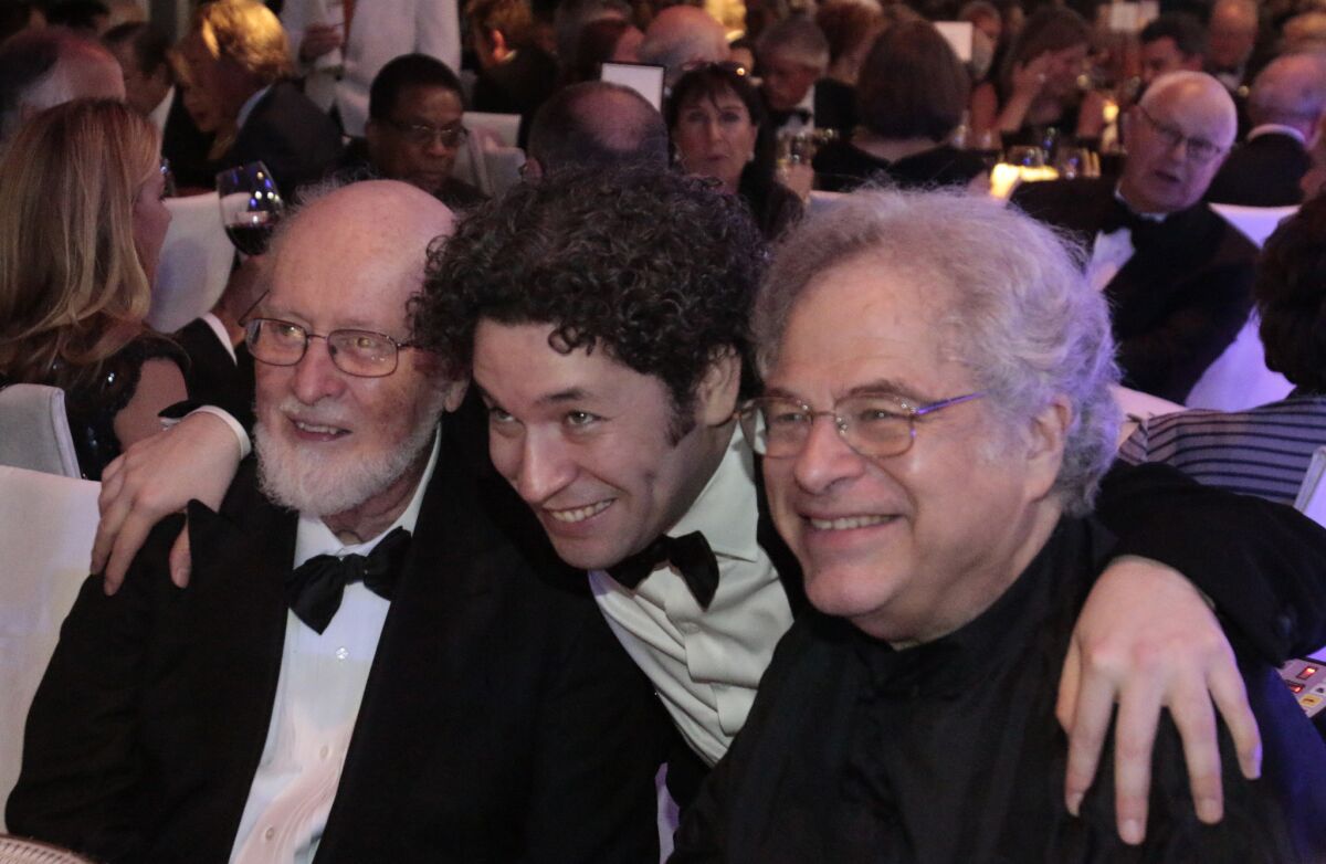 Gustavo Dudamel, center, poses for a picture with composer John Williams, left, and violinist Itzhak Perlman at the gala dinner after the LA Phil's season opening concert at Walt Disney Concert Hall.