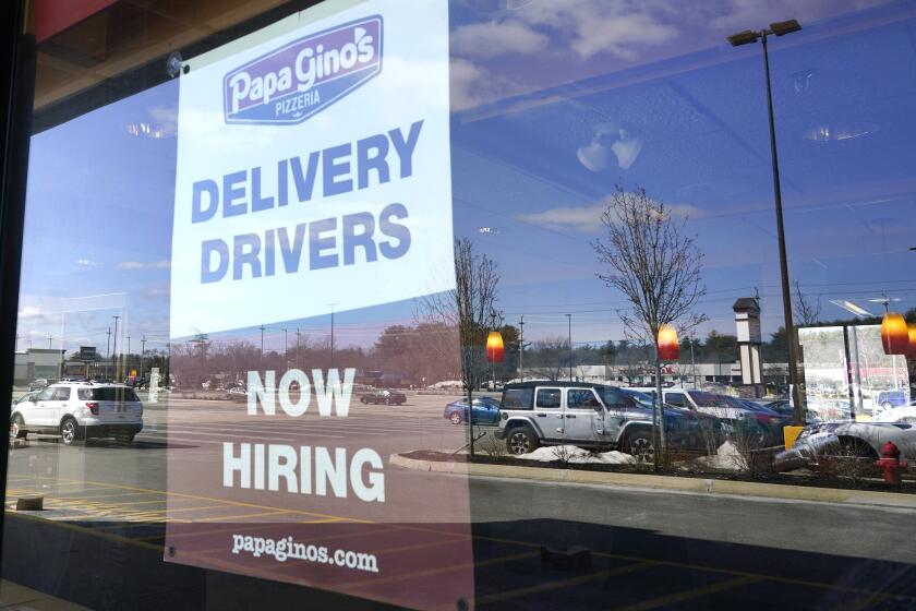 A "Now Hiring" sign is displayed, Thursday, March 4, 2021, in Salem, N.H. After a year of ghostly airports, empty sports stadiums and constant Zoom meetings, growing evidence suggests that the economy is strengthening. Hiring picked up in February 2021. Business restrictions have eased as the pace of viral infections has ebbed. Yet the economy remains far from normal. (AP Photo/Elise Amendola)