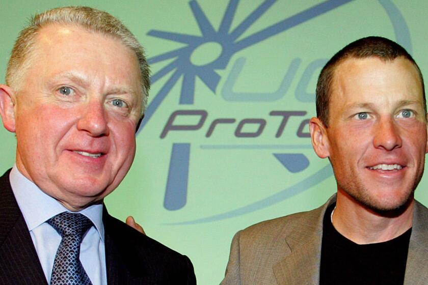 Former International Cycling Union President Hein Verbruggen, left, poses for a photo with cyclist Lance Armstrong in Paris in 2003.
