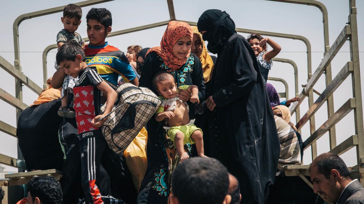 Civilians who recently fled territory formerly controlled by Islamic State militants disembark from a truck at the Dibaga camp for displaced people in Hajj Ali, northern Iraq.