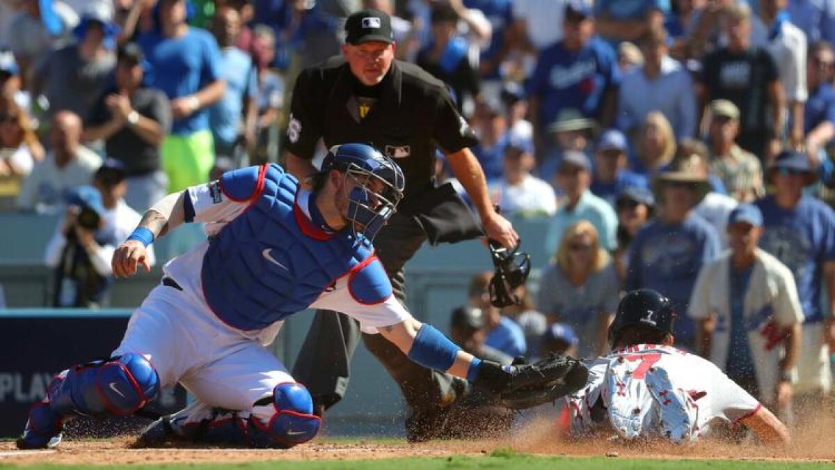 Dodgers catcher Yasmani Grandal is late with the tag on Trea Turner who scored in the third inning.