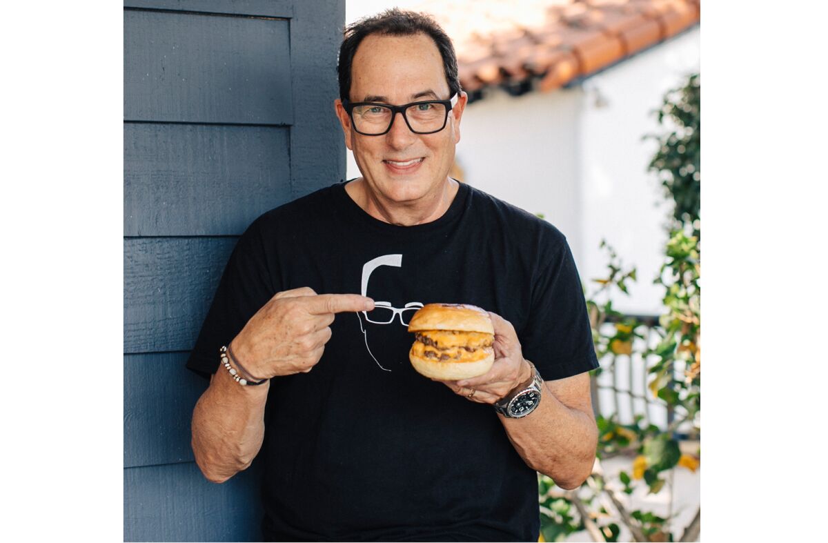 Sam "The Cooking Guy" Zien holds of the burgers from Eats by Sam 