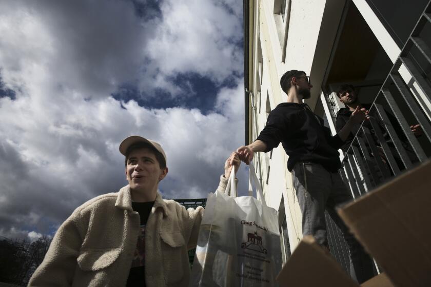 From left, Danya, 21, Gabriel, 21 and Borden, 17 all refugees from Odesa, Ukraine help to deliver bags with food to needy people during preparations for the celebration of Jewish Passover at the Chabad Jewish Education Center in Berlin, Germany, Thursday, April 7, 2022. Rabbis and Jewish organizations are working round the clock within Ukraine, Eastern Europe and other parts of Europe to make sure that Jews who remain in Ukraine and refugees who have fled as far away as Israel are able to celebrate Passover. (AP Photo/Markus Schreiber)