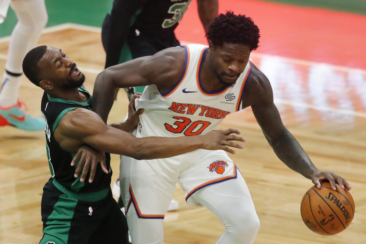 Julius Randle de los Knicks de NUeva York intenta alejar el balón de Kemba Walker de los Celtics