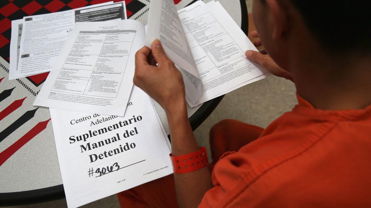 An immigrant detainee reads through paperwork in a general population block at the Adelanto Detention Facility in Adelanto, Calif. The facility is managed by the private GEO Group.