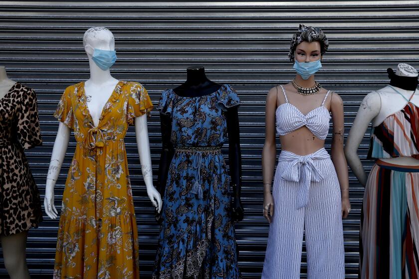 LOS ANGELES, CALIF. - MAY 28, 2020. Mannequins wear protective masks in the garment district in downtown Los Angeles on Thursday, May 28, 2020. Most of the area's shops are off to a slow reopening after being shuttered since coronavirus lockdowns were imposed on businesses in March. (Luis Sinco/Los Angeles Times)