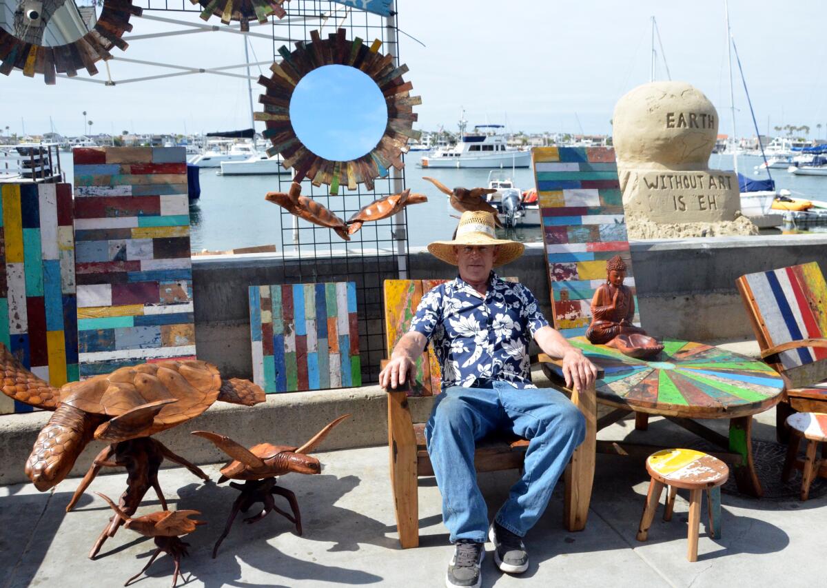 Gerald Carroll sits with his carved turtles and teak pieces reclaimed from old fishing boats.