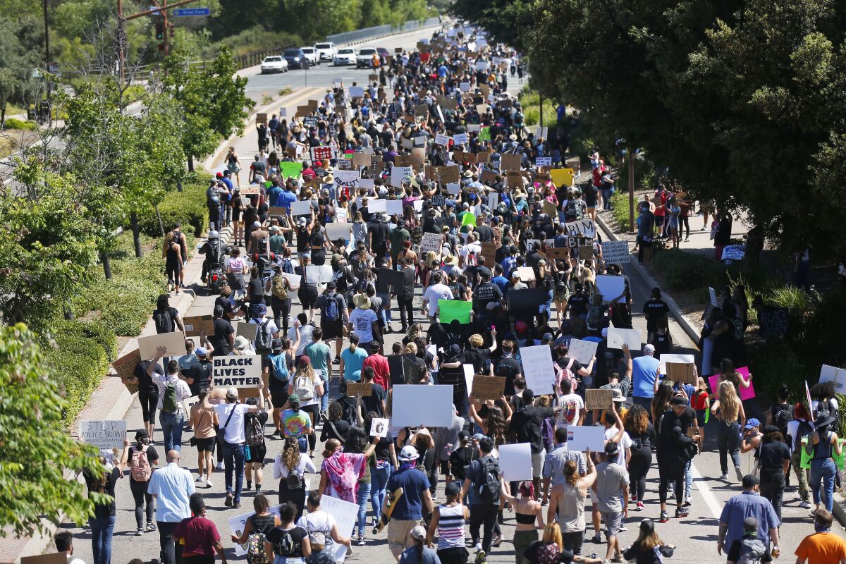 Black Lives Matter supporters walk down toward the San Diego Sheriff's Department station in Santee during a protest in June.