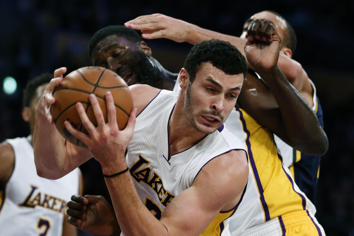 Lakers forward Larry Nance Jr. pulls down a rebound in front of teammate Roy Hibbert and Jazz center Rudy Gobert during the first half Sunday at Staples Center.
