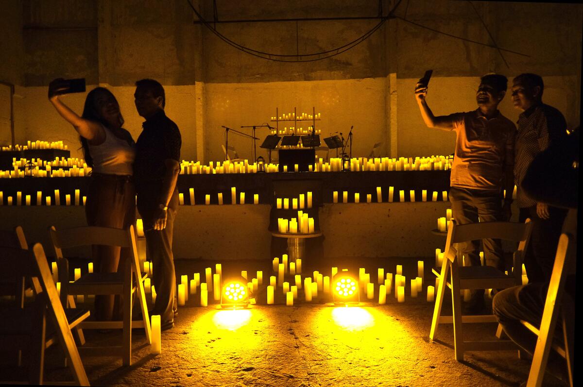 People take photographs before a candlelight concert on Aug.12, 2022, in Tijuana, Mexico.