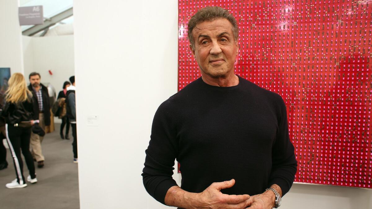 Sylvester Stallone stands in front of art by Tatsuo Miyajima at Frieze Los Angeles on Thursday.