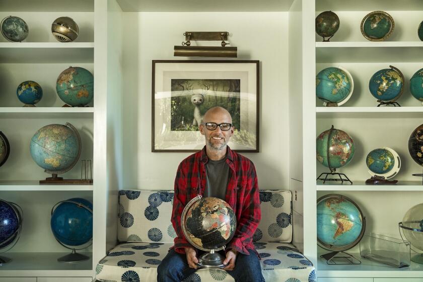 Moby holds his first globe, which he purchased as a child shopping with his mother at a thrift store. He collects vintage globes that show country place names that have disappeared into history, such as Rhodesia and Indochina. "It's an object lesson in impermanence," he says.