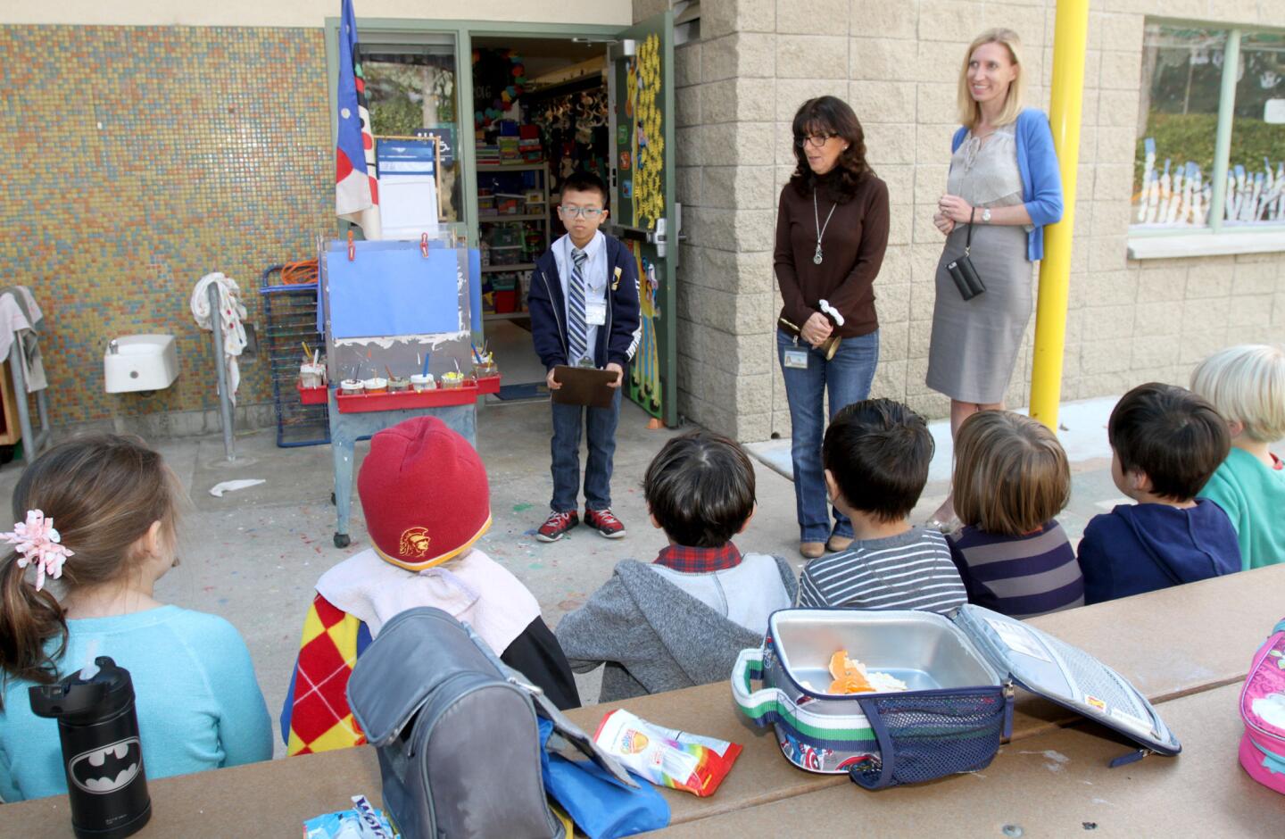 With La Cañada Elementary School transitional Kindergarten teacher Pam Daniger, second from right, and Principal Emily Blaney looking on, fifth-grader Michael Kwan, the principal for a day, explains the virtues of picking up trash and leaving the school eating area clean to fellow students.