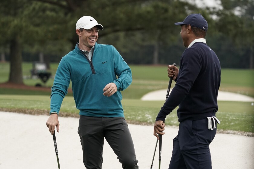 Tiger Woods is greeted by Rory McIlroy, of Northern Ireland during a practice round for the Masters golf tournament on Tuesday, April 5, 2022, in Augusta, Ga. (AP Photo/Charlie Riedel)