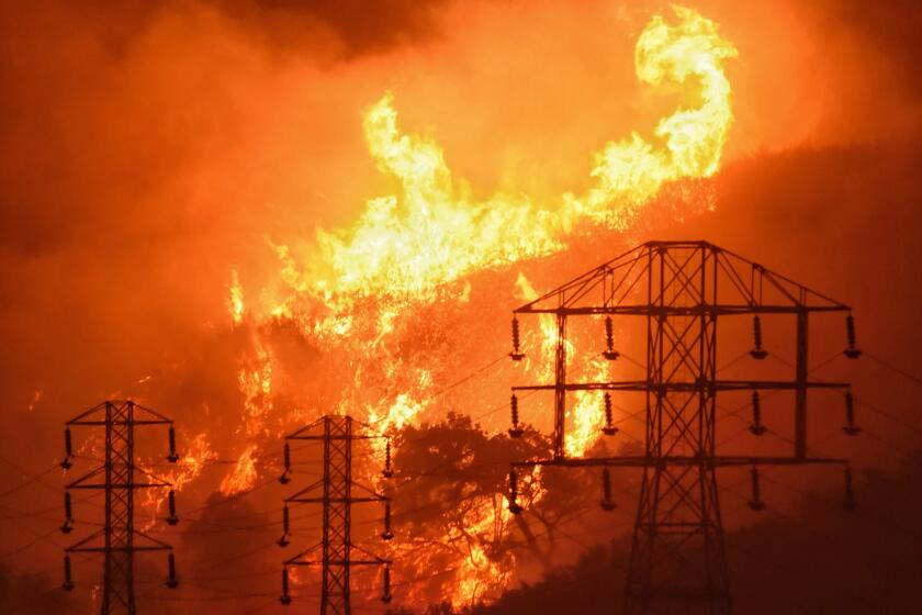 FILE - In this Dec. 16, 2017, file photo provided by the Santa Barbara County Fire Department, flames burn near power lines in Sycamore Canyon near West Mountain Drive in Montecito, Calif. A Wednesday, July 10, 2019, report in the Wall Street Journal says Pacific Gas & Electric, which is blamed for some of California's deadliest recent fires, knew for years that dozens of its aging power lines posed a wildfire threat but avoided replacing or repairing them. PG&E says it disagrees with the Journal's conclusions but says its "taking significant actions to inspect, identify, and fix" safety issues. (Mike Eliason/Santa Barbara County Fire Department via AP, File)
