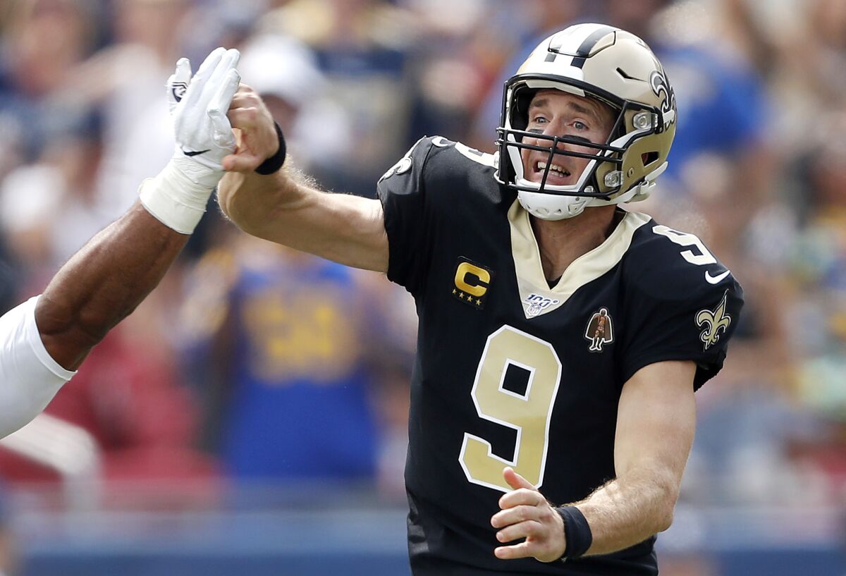 Saints quarterback Drew Brees injures the thumb on his throwing hand as he is hit by Aaron Donald of the Rams during the first quarter of their game Sunday.