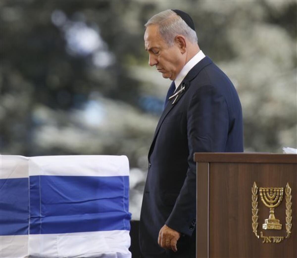 El primer ministro israelí, Benjamin Netanyahu, psada junto al ataúd que contiene los restos mortales del expresidente Shimon Peres, envuelto en la bandera de Israel, tras intervenir en su funeral en el cementerio nacional del Monte Herzel, en Jerusalén, el 30 de septiembre de 2016.