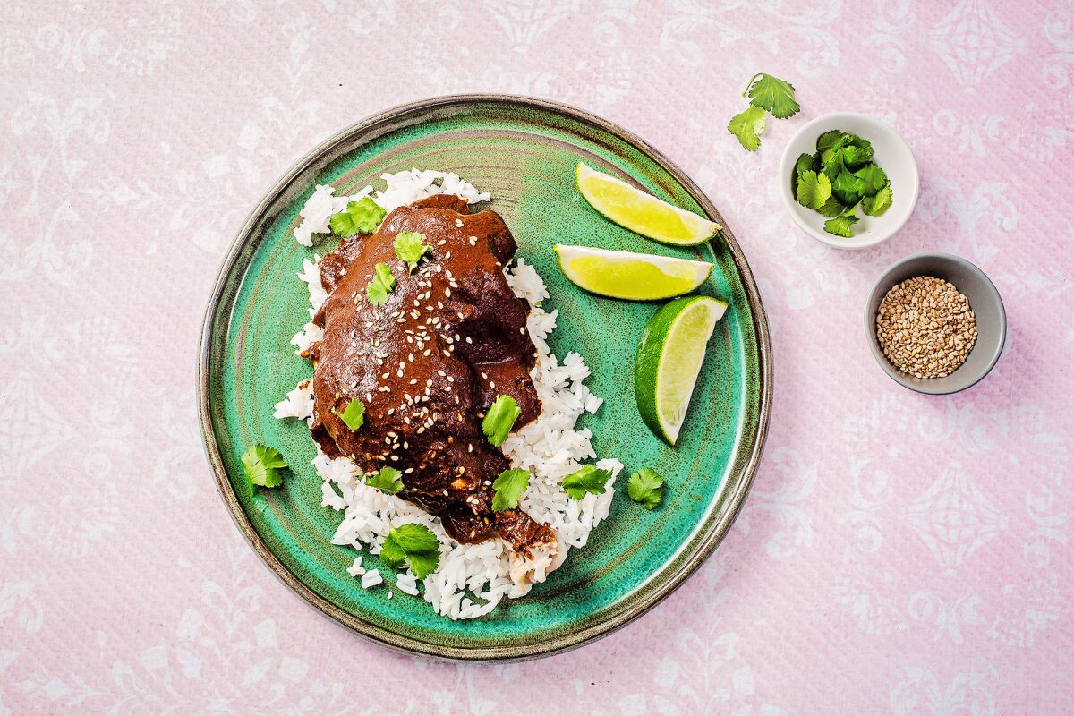 Oaxacan-style Mole Negro served over a chicken quarter and white rice.