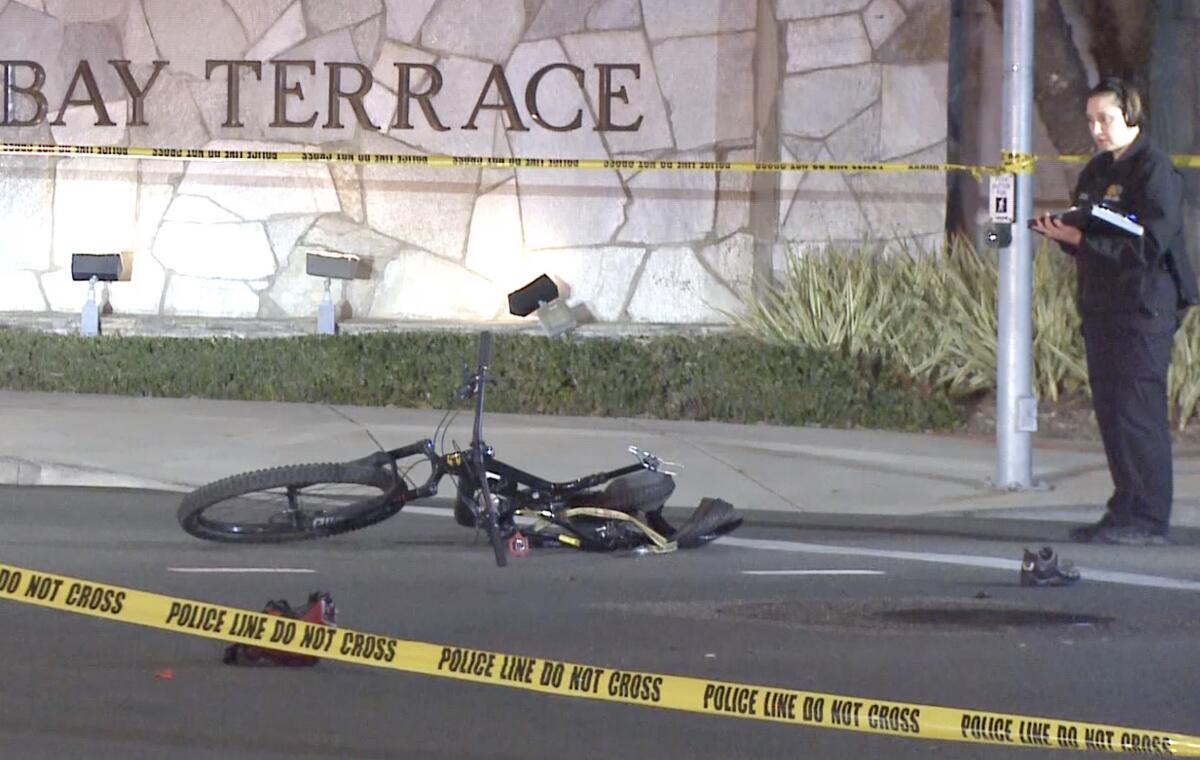 A bicycle overturned on the street behind yellow police tape