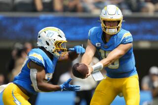  Chargers quarterback Justin Herbert (10) hands off the ball to running back J.K. Dobbins (27).