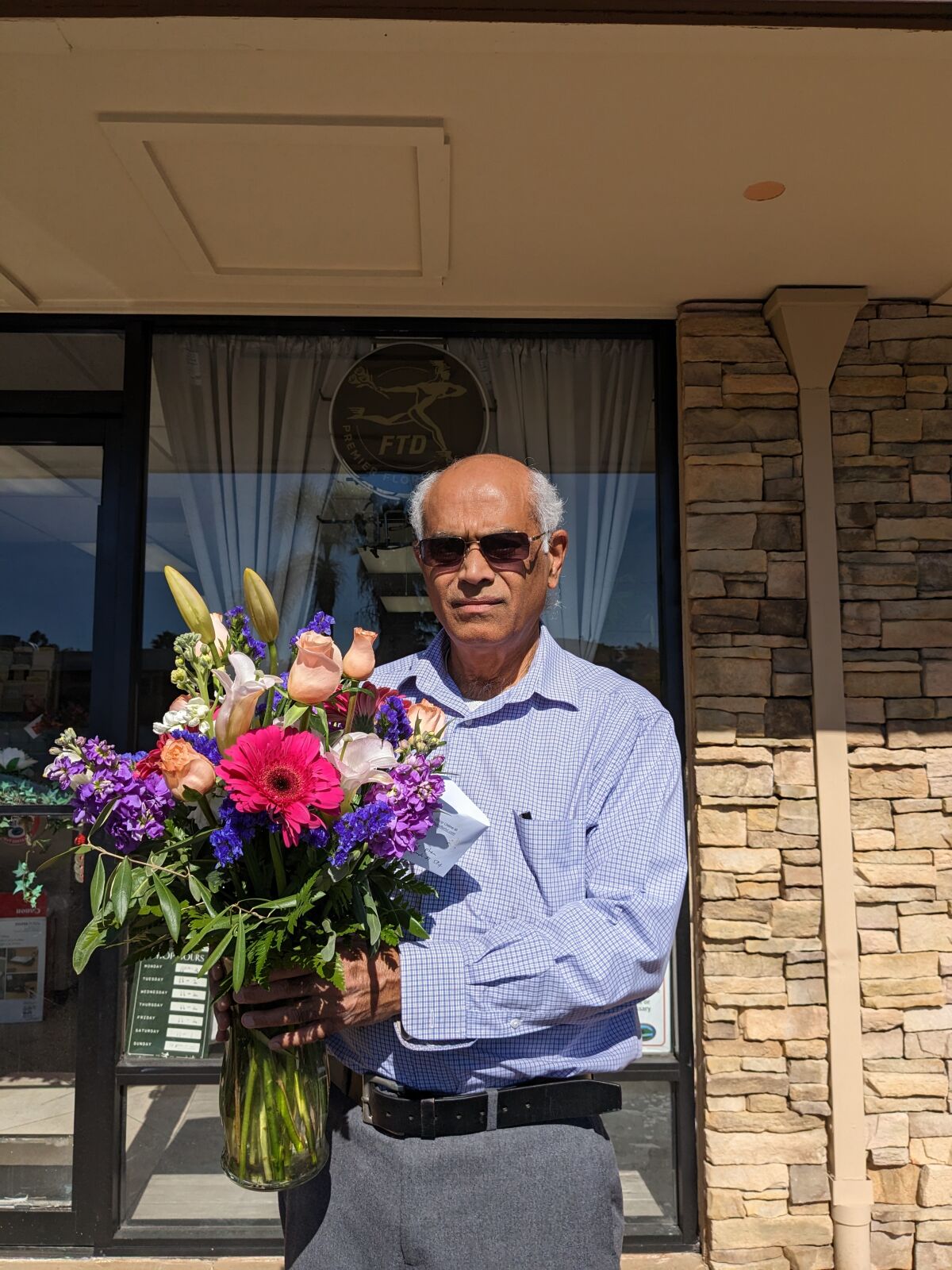 Naren Rathod, owner of Dhuns Poway Florist, poses with a bouquet in front of his shop as he prepares for Valentine’s Day.