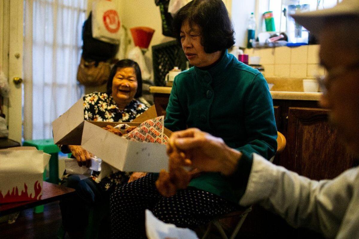 Pang Yun Fei, 77, Mei Wong, 67, and Yizhong Huang, 75, try chicken from Howlin' Ray's.