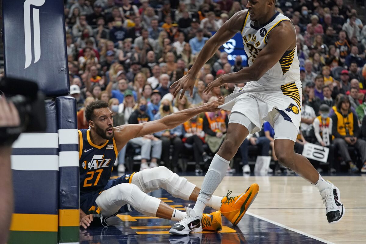Utah Jazz center Rudy Gobert (27) pulls Indiana Pacers center Myles Turner (33) to the floor in the second half during an NBA basketball game Thursday, Nov. 11, 2021, in Salt Lake City. Gobert and Turner were ejected from the game. (AP Photo/Rick Bowmer)