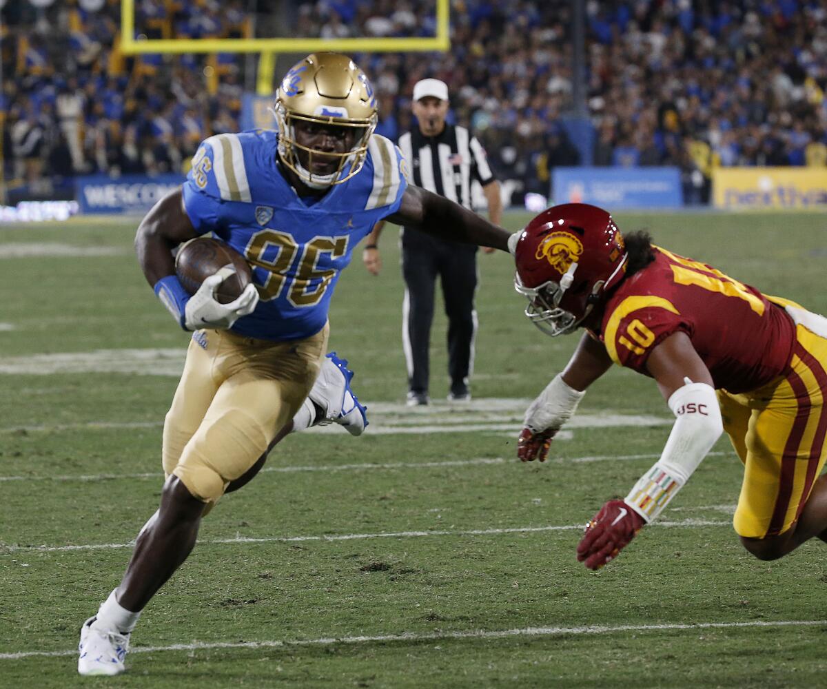 Michael Ezeike runs with the ball for UCLA.