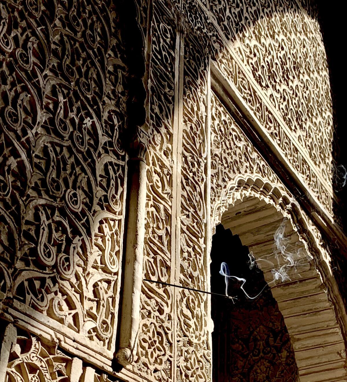 A stick of incense burns from one of the sumptuously decorated stucco walls at Bou Inania Medersa, a residential religious school built in the 14th century in the old walled city in Fez.