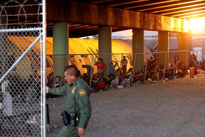 Hundreds of migrants seeking asylum are held in a temporary transition area under the Paso Del Norte bridge in El Paso, Texas.