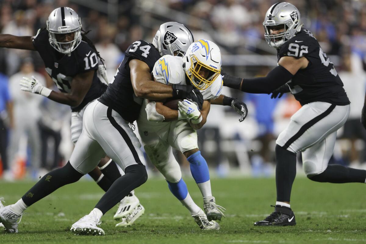 Raiders linebacker K.J. Wright (34) tackles Chargers running back Austin Ekeler (30) in the first half.