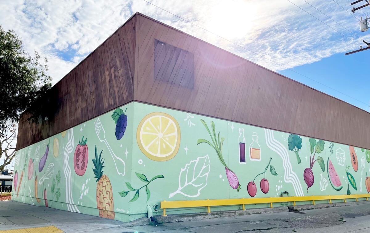 Giant sized kitchen items and food painted by Hanna Daly wrap around the Kitchens for Good shop in Pacific Beach.
