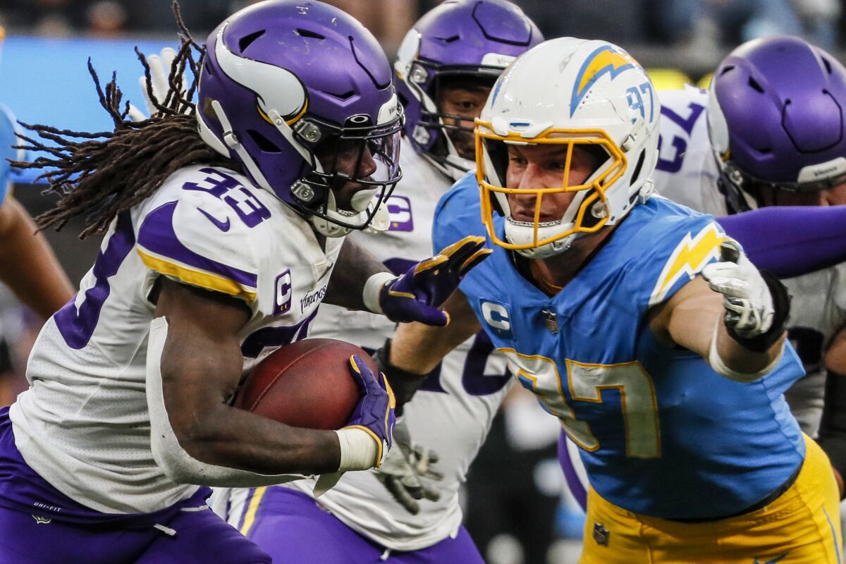 Minnesota Vikings running back Dalvin Cook is chased by Chargers defensive end Joey Bosa.