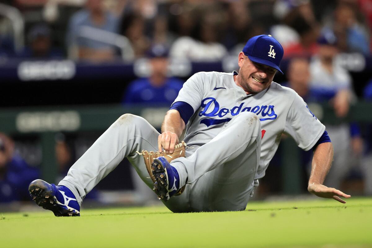 Dodgers relief pitcher Daniel Hudson falls to the ground after sustaining a torn ACL against the Atlanta Braves on Friday.