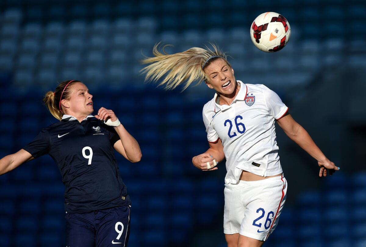 U.S. defender Julie Johnston heads the ball away from French forward Eugenie Le Commer, left, during the Algarve Cup final. The U.S. beat France, 2-0.