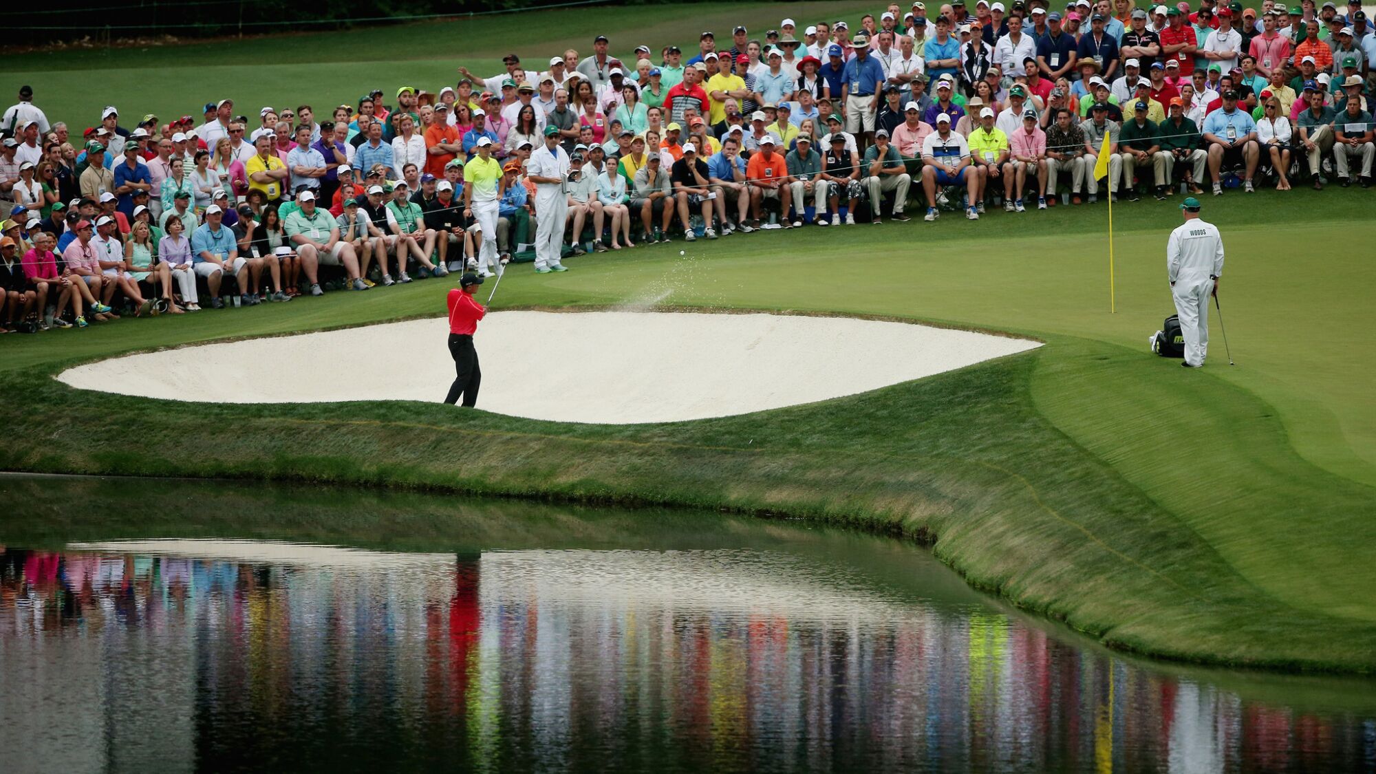 Tiger Woods plays out of a bunker on the 16th hole at Augusta National Golf Club on April 12, 2015.