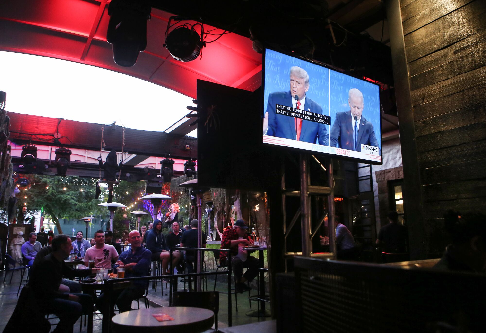 A patio TV shows the debate at a restaurant