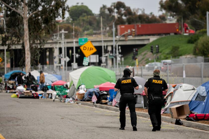 OCEANSIDE, CA - APRIL 13: Oceanside Police being clearing a homeless encampment near Oceanside Boulevard on Tuesday, April 13, 2021 in Oceanside, CA. Oceanside Police, along with various homeless service providers, arrived at the camp Tuesday morning offering vouchers for hotels and transporting people and their belongings to the hotels and into storage. (Sam Hodgson / The San Diego Union-Tribune)`