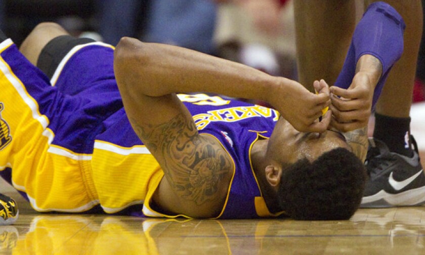 Lakers guard Kent Bazemore lies on the court after tearing a tendon in his right foot during Sunday's 120-97 loss to the Clippers at Staples Center.