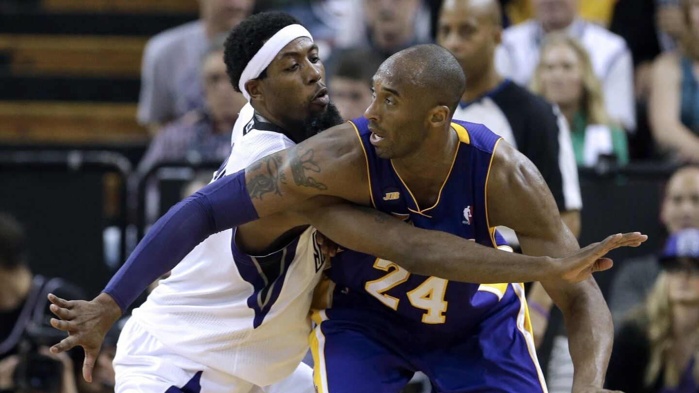 Lakers guard Kobe Bryant, right, protects the ball from Sacramento Kings forward John Salmons during the Lakers' 103-98 win on March 30, 2013.