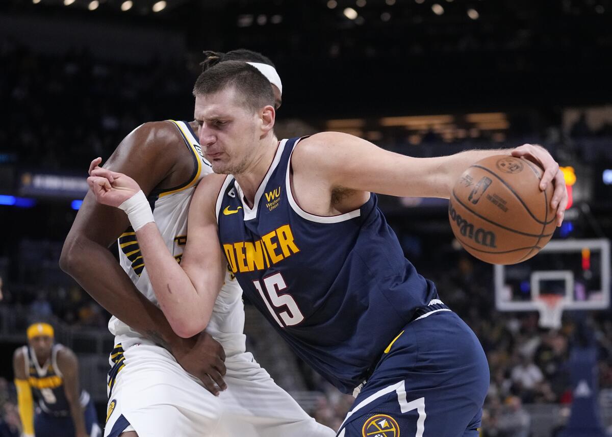 Denver Nuggets' Nikola Jokic (15) goes to the basket against Indiana Pacers' Myles Turner during the first half of an NBA basketball game, Wednesday, Nov. 9, 2022, in Indianapolis. (AP Photo/Darron Cummings)