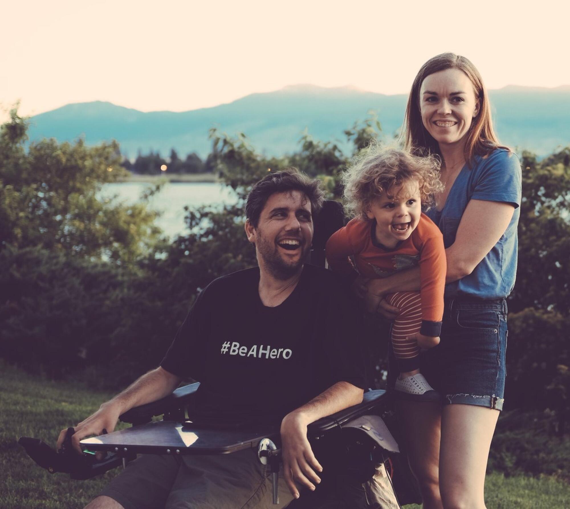 A man in a wheelchair with a woman and a small child.