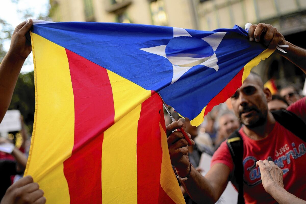 Supporters of Spanish unity cut up a flag used by those who support independence for the Catalan region during a protest in Barcelona on July 30.