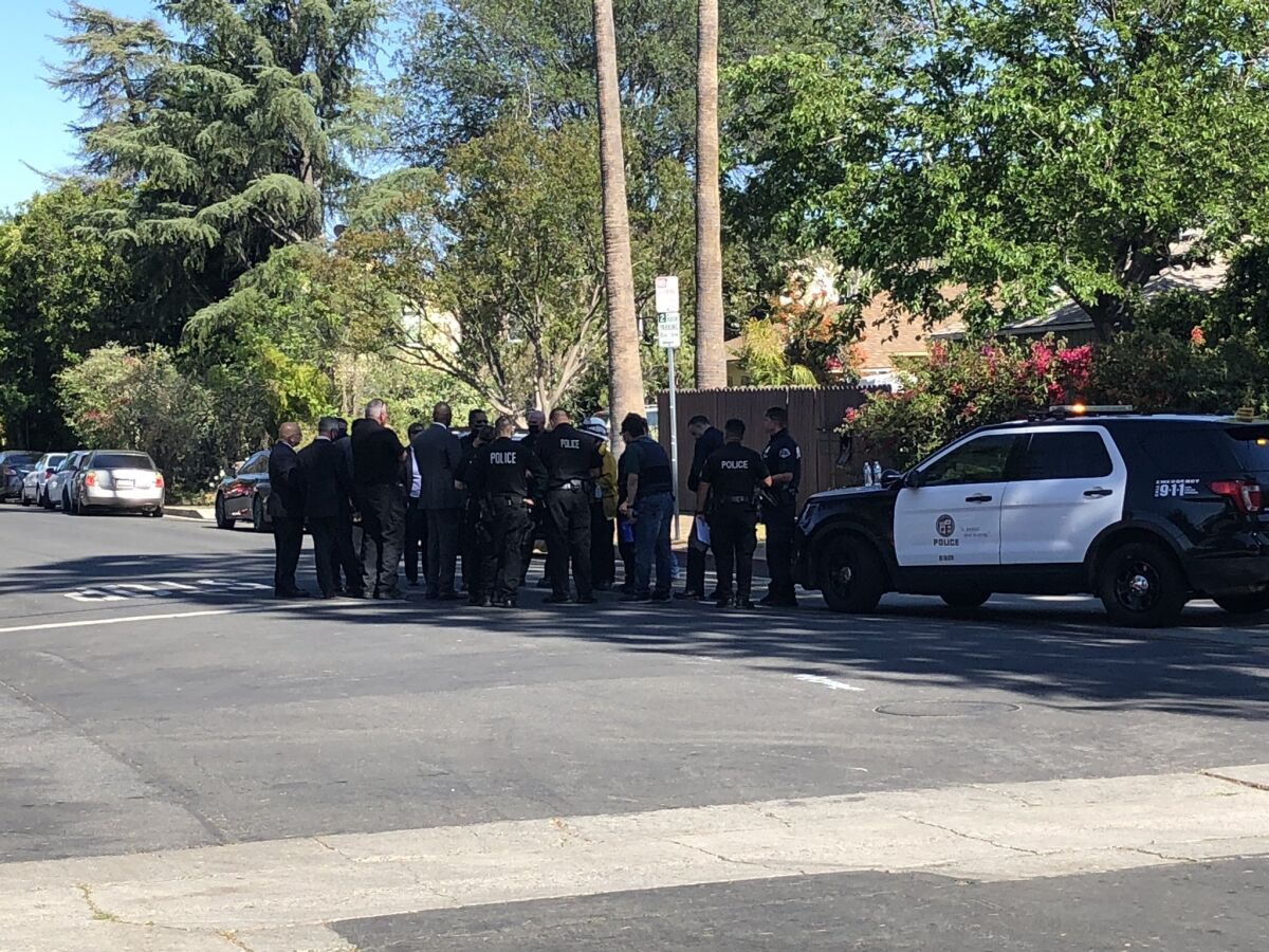 Investigators gather near the scene where an off-duty LAPD officer was shot  Wednesday.