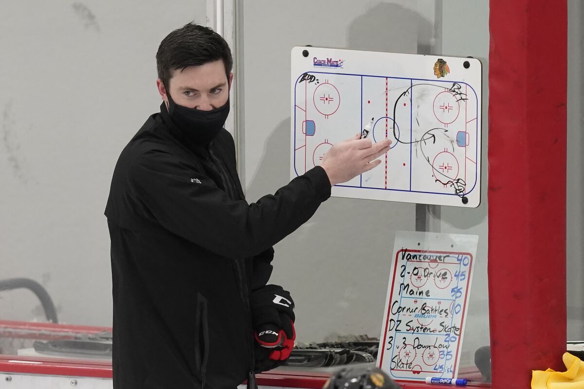 Chicago Blackhawks head coach Jeremy Colliton sets up a drill during an NHL hockey training camp practice Monday, Jan. 4, 2021, in Chicago. (AP Photo/Charles Rex Arbogast)