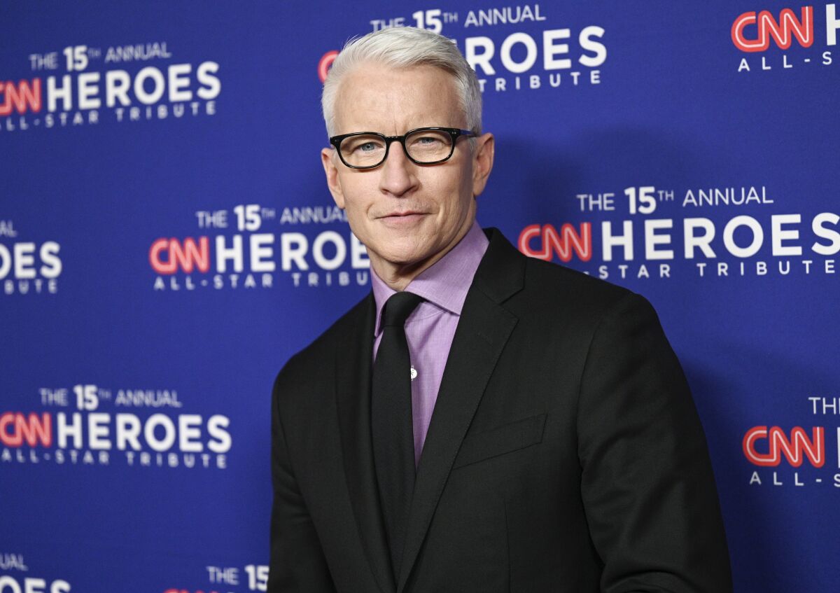 A man with white hair wearing glasses and a suit.