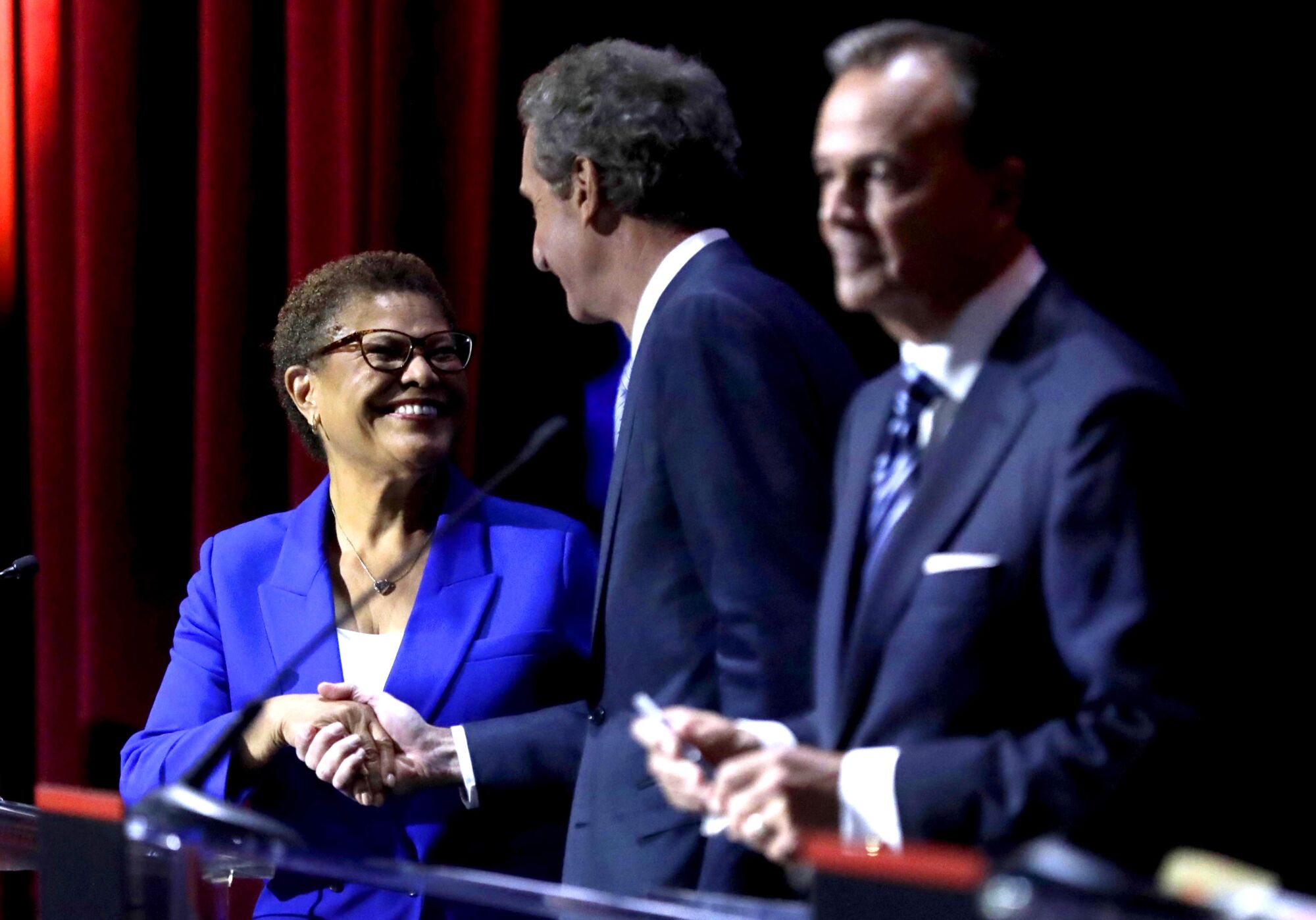 Rep. Karen Bass, left, is greeted by Los Angeles City Attorney Mike Feuer as businessman Rick Caruso waits.