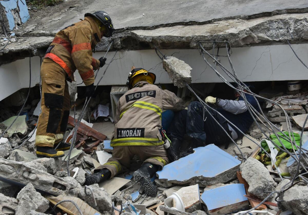 Rescue workers search for survivors in Gauyaquil, Ecuador, on Sunday after a massive earthquake