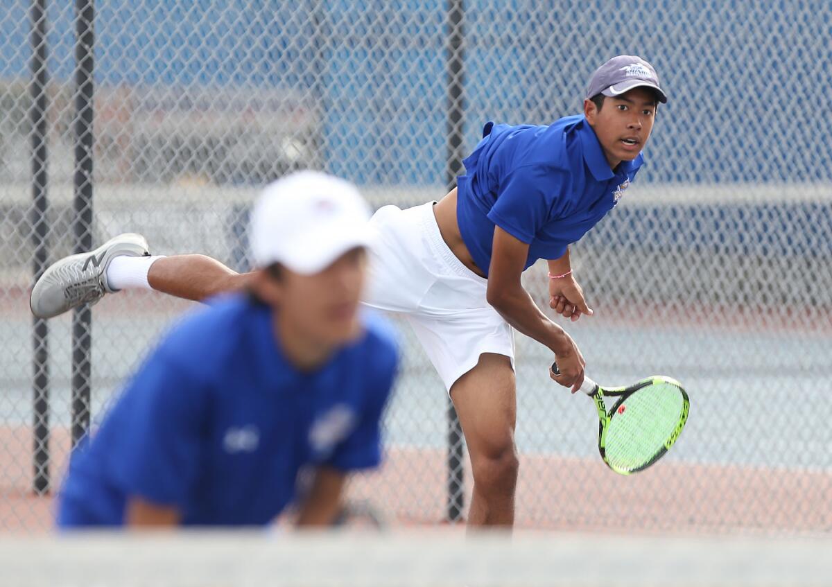 Fountain Valley's Kai Rodriguez, right, hits a hard serve with partner Nathan Dang in March 2020.